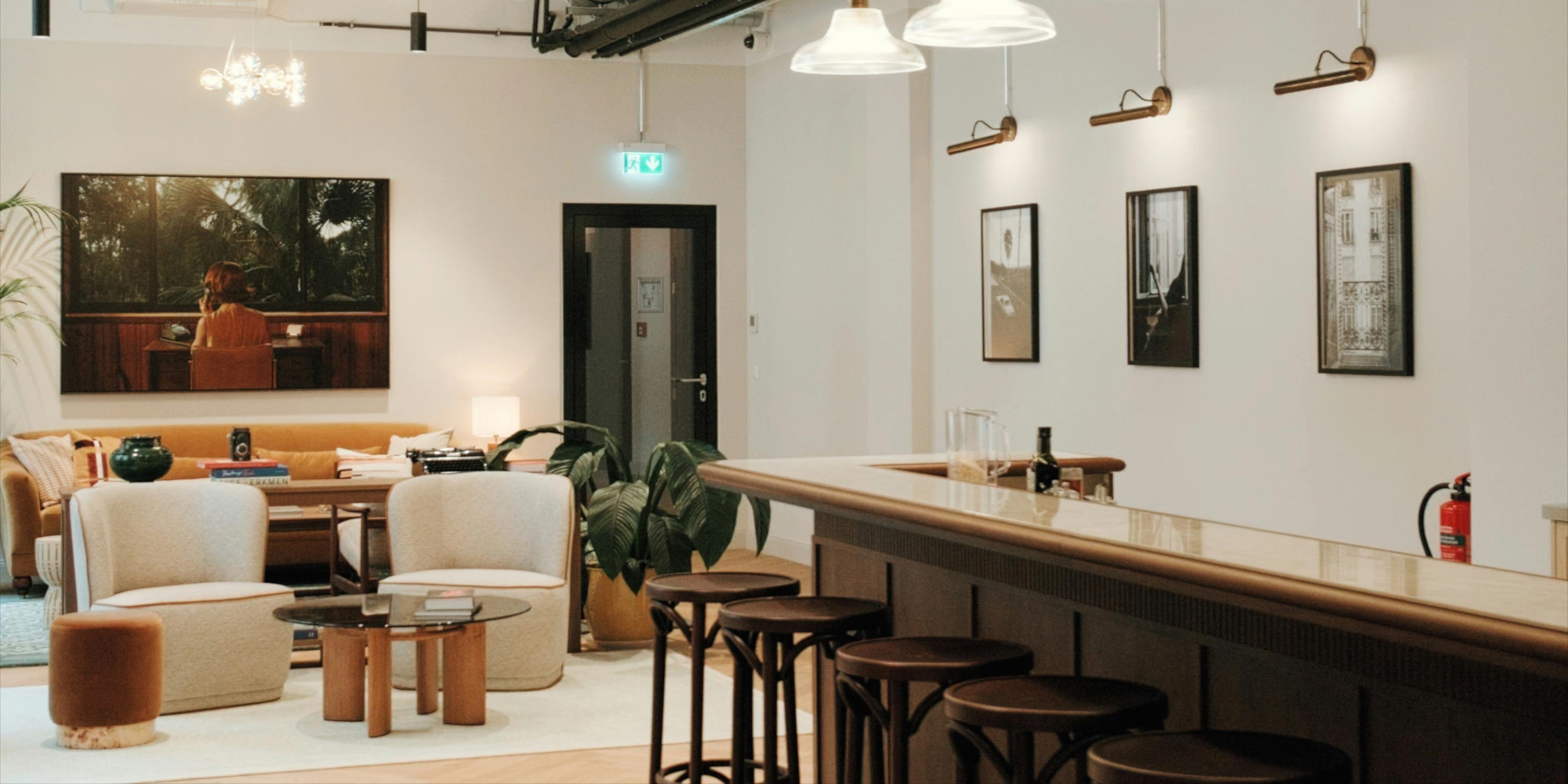 Cozy lounge area with a bar, modern seating, and warm lighting