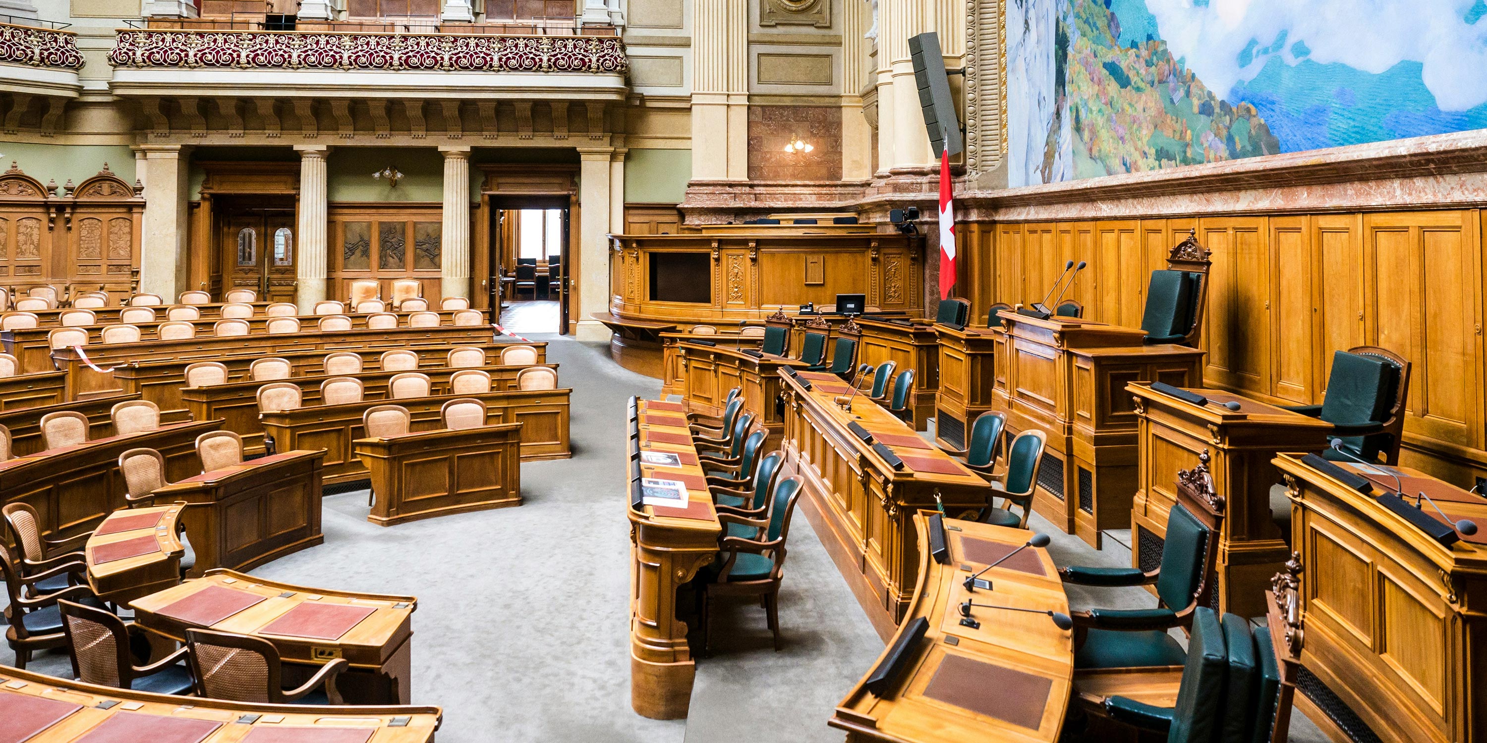 Elegant government chamber with wooden desks and green chairs