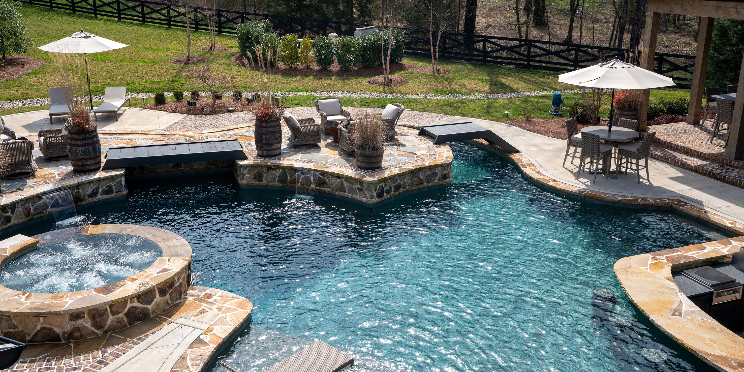 Outdoor pool and spa area with seating and lush landscaping