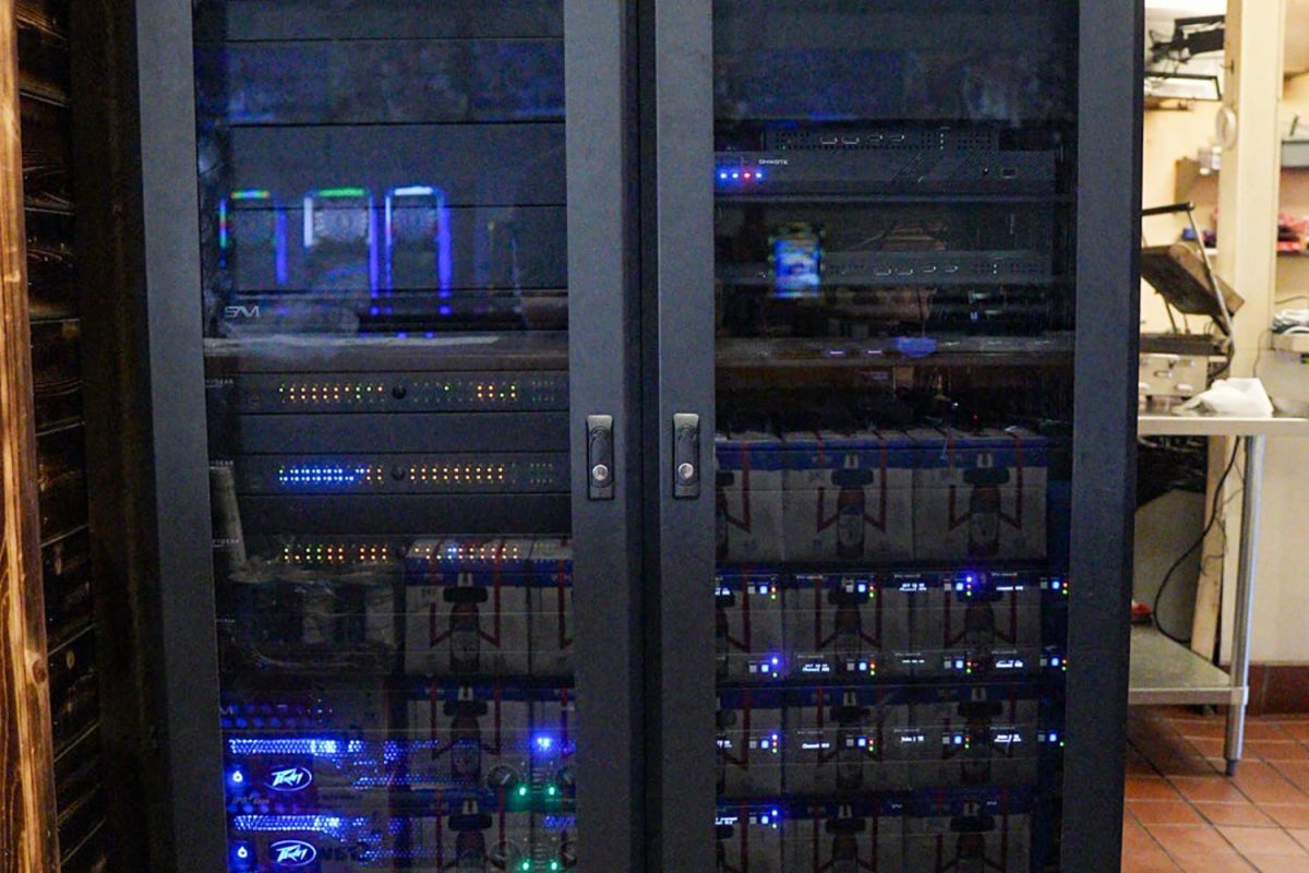 Server rack with illuminated network equipment inside a dimly lit room
