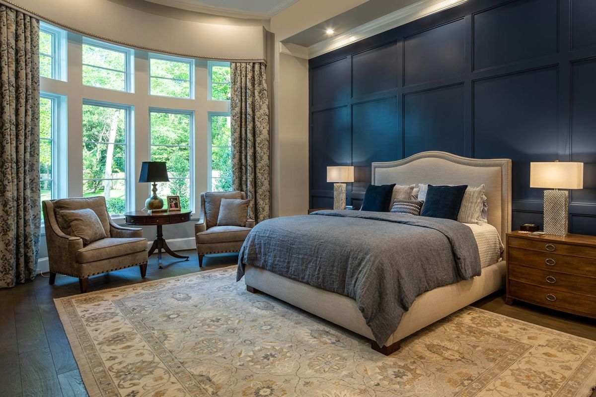 Elegant bedroom with dark accent wall and curved window
