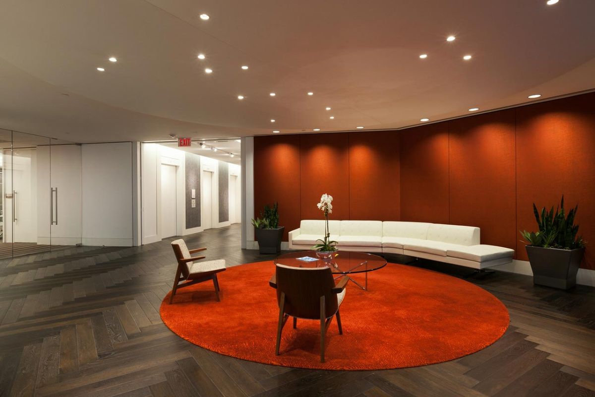 Office lobby with red round rug and white sectional sofa